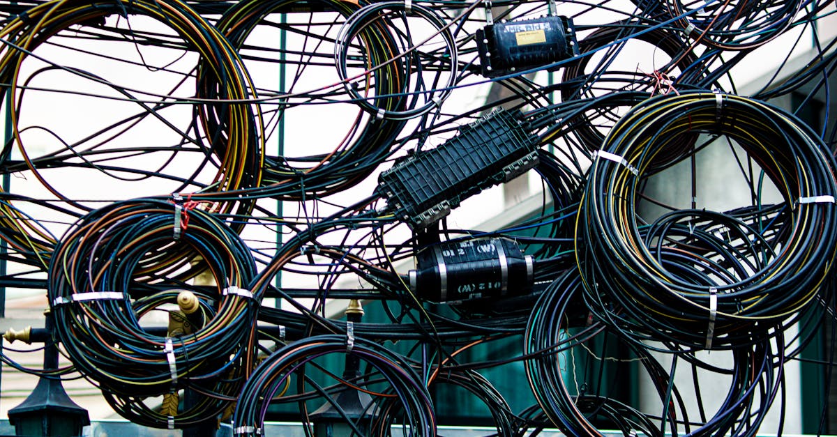 Intricate network of tangled power and communication cables outdoors.