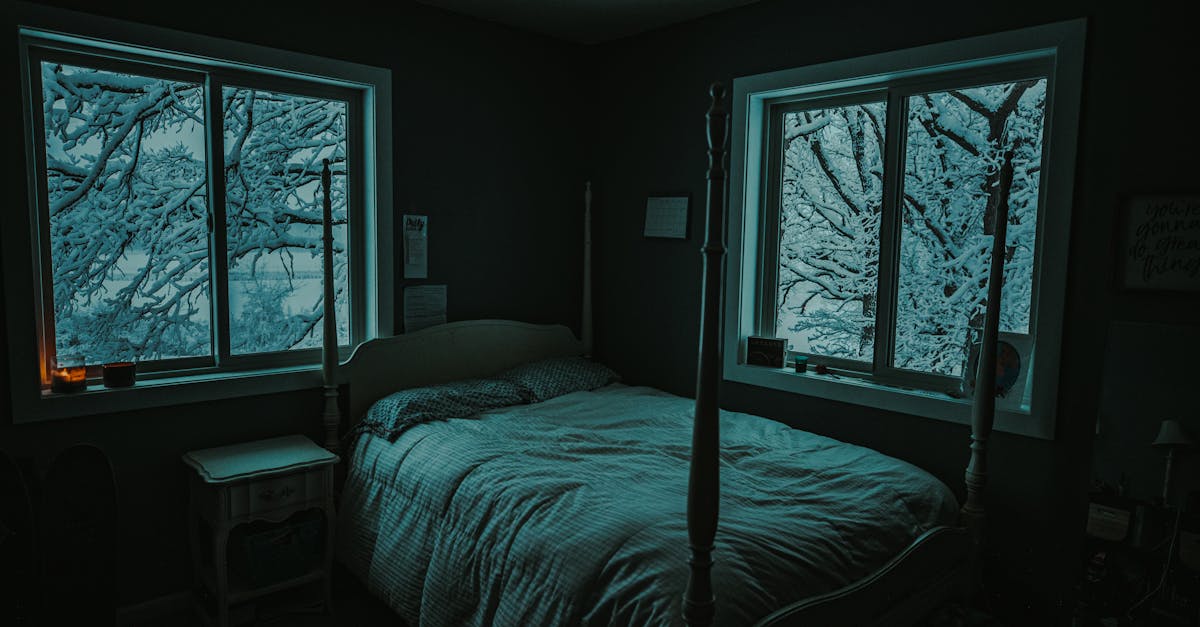 Serene bedroom interior with snowy tree scenery outside, creating a cozy winter ambiance.