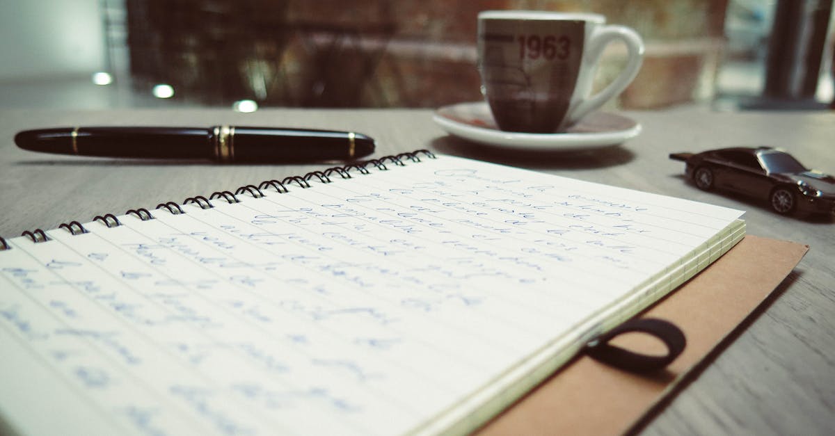 A warm, inviting workspace featuring coffee, handwritten notes, and a pen on the desk.