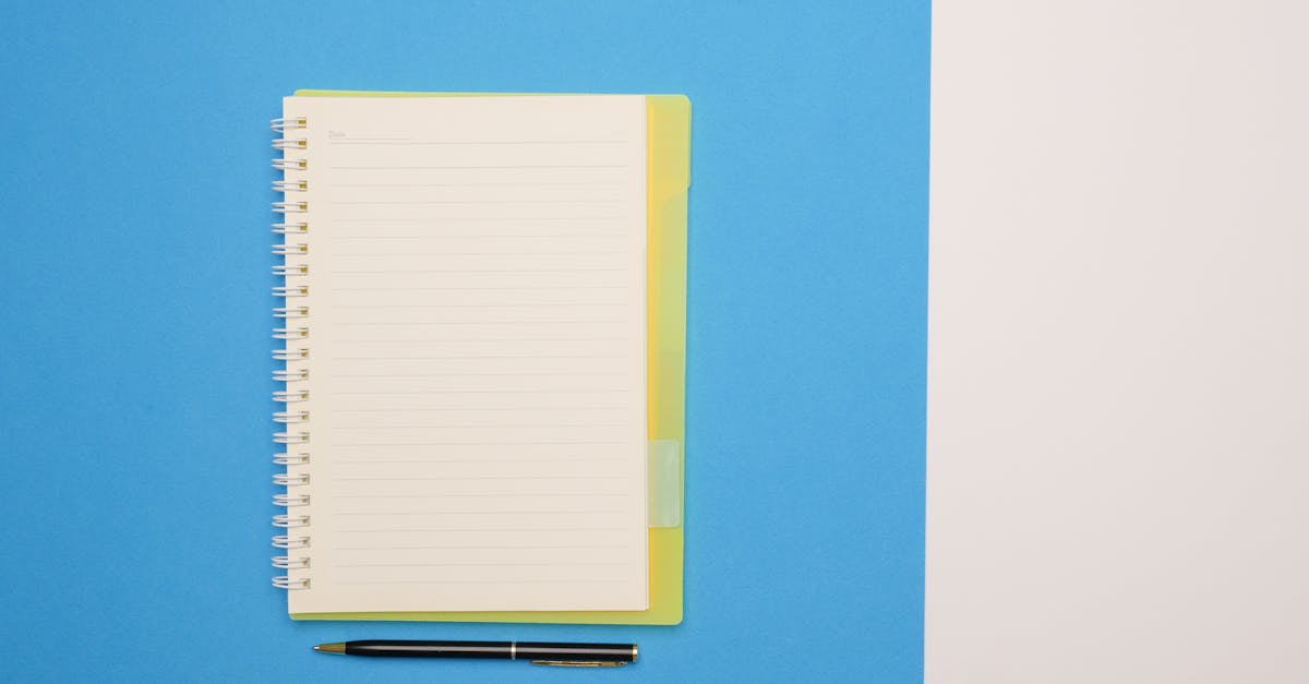 Top view of a spiral notebook and pen on a blue and white surface, ideal for mockups.